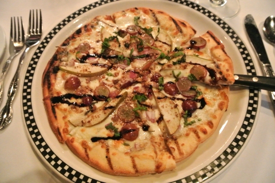Brie And Pear - a pizza crust topped with brie, pears, grapes, candied pecans and red onion with a balsamic reduction